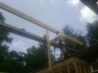 Carpenter setting a ridge beam over a new addition frame — Ice Dam Removal by Roofing Brothers in Blairs Mills