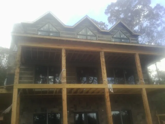 Dormers and porch framing on a large log home under construction — Roof Coating work by our crew in Blairs Mills
